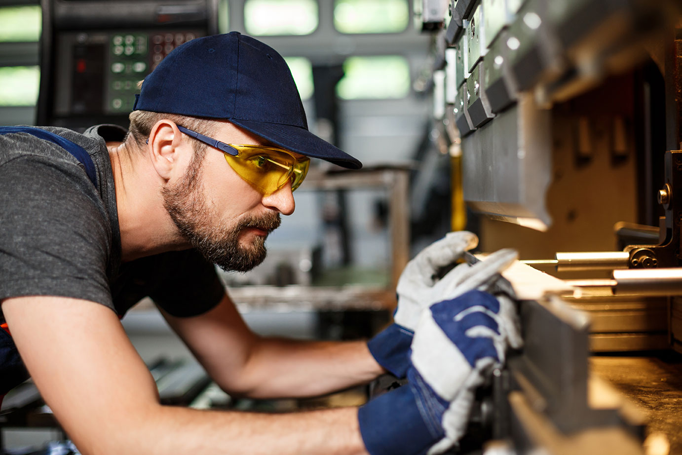 worker-wearing-gloves-working-on-metal